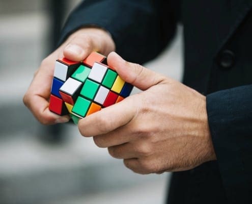 Mental Health Solving Problems - Man with ruby cube working out problems concept.